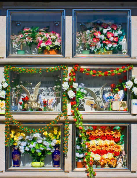 Burial niches  decorated with multi colored flowers. Close-up front view. Day of the Dead traditional ritual decoration. Lugo city, Galicia, Spain.