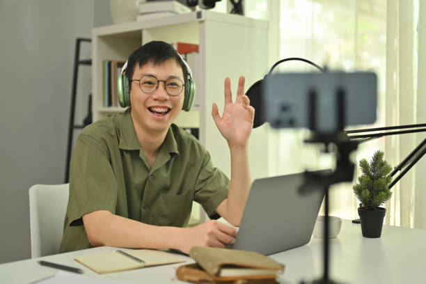 istock Young man podcaster speaking into a condenser microphone, recording podcast on smartphone at home studio. 1487000080