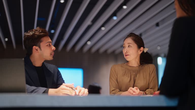 Three multi-ethnic business people having business discussion in office