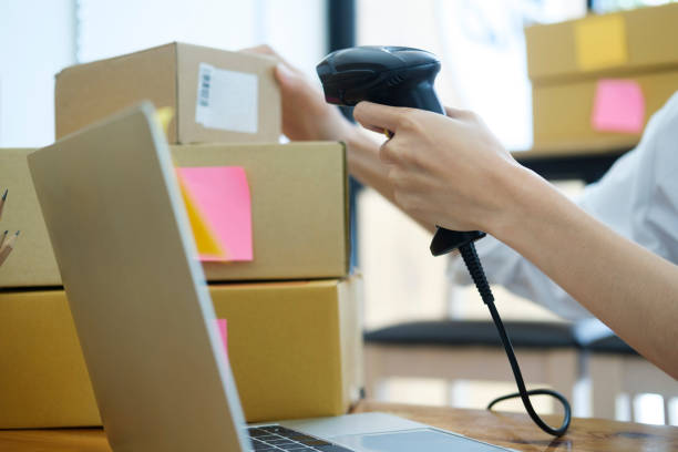 istock Female online business owner scanning parcel barcode tag. 1487002214