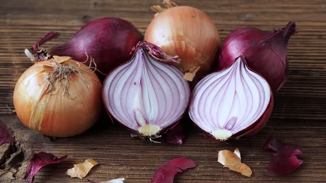 Yellow and red onions on a wooden board