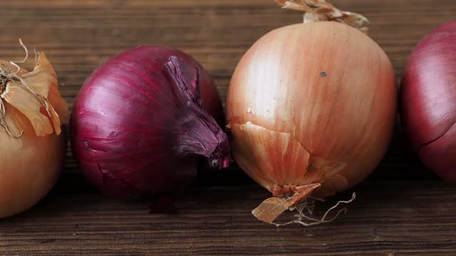 Yellow and red onions on a wooden board