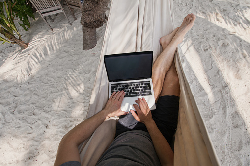 istock workation, remote work, freelancer with laptop in hammock 1487006161