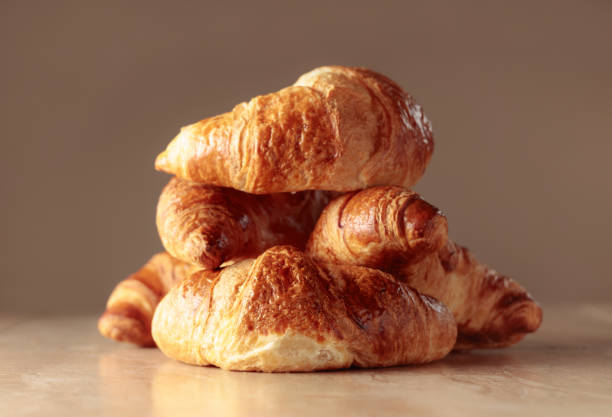 istock Freshly baked croissants on a beige ceramic table. 1487007827