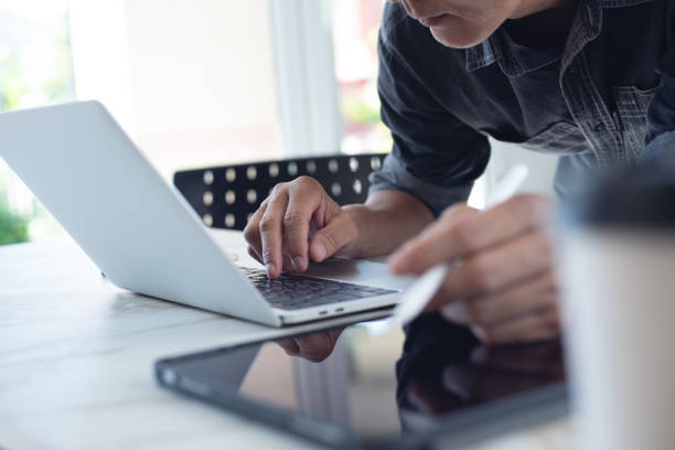 istock Business man working on laptop computer at office, close up 1487007849