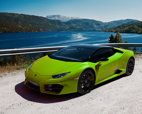 Road trip in a green Lamborghini Huracan, engine V10, 580 HP. The car parked by a lake in the mountains. Gransherad, Norway. 04.06.2016