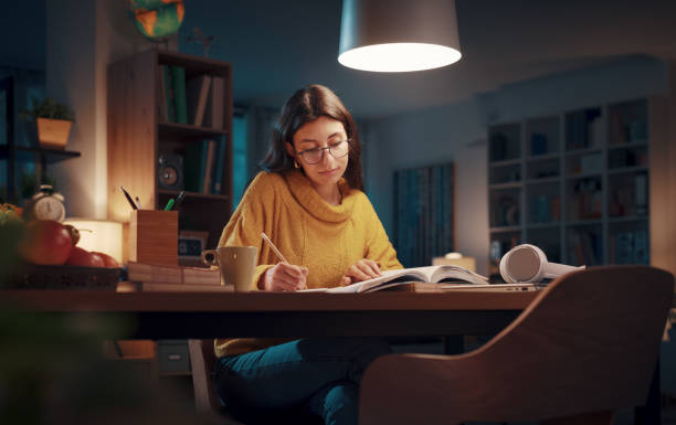 Young woman studying late at night stock photo