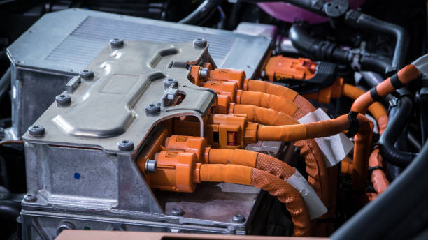 istock Powerful orange cables connecting the electric vehicle engine, inverter, traction battery and air conditioning compressor. EV maintenance concept. 1487012011