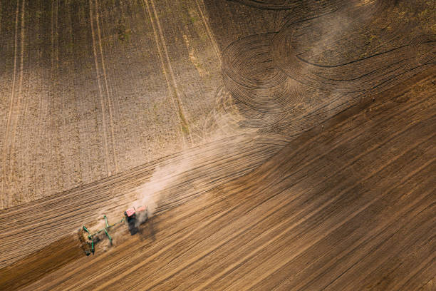 istock Aerial View. Tractor Plowing Field. Beginning Of Agricultural Spring Season. Cultivator Pulled By A Tractor In Countryside Rural Field Landscape. Dust Rises From Under Plows 1487013149