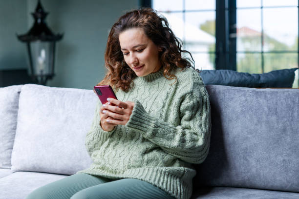 istock Young woman using phone at home 1487013346