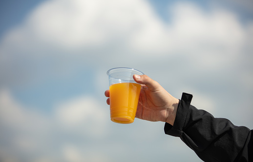 Orange juice with colored backgrounds in plastic cup.
