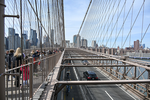 New York City, United States, April 8, 2023 - Car traffic, pedestrians and bicyclists on Brooklyn Bridge in New York.