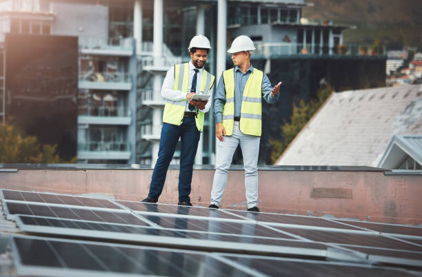 istock Solar panels, engineering and people with tablet for construction, maintenance and renewable energy. Urban sustainability, teamwork and electricians with digital tech for photovoltaic electricity 1487016125