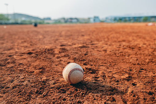 This is a photo of a baseball scattered on the baseball field after being hit.
