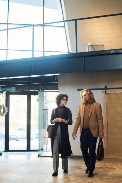 istock Two mature colleagues in quiet luxury attire discussing working points 1487017073