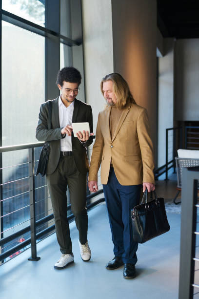 istock Two intercultural businessmen discussing online financial data in tablet 1487017136