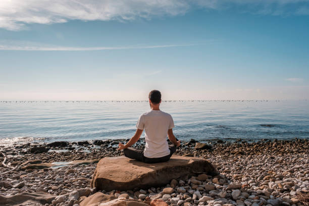 istock Attractive young man practicing yoga meditation and breathwork outdoors by the sea 1487018207