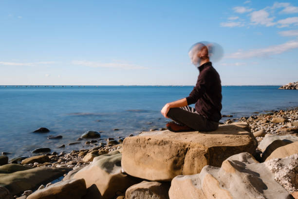 istock Attractive young man practicing yoga meditation and breathwork outdoors by the sea 1487018223