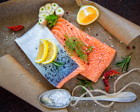 Salmon fillet on paper with ingredients.