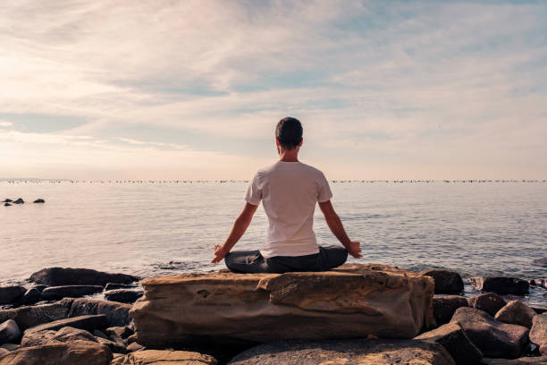 istock Attractive young man practicing yoga meditation and breathwork outdoors by the sea 1487018627