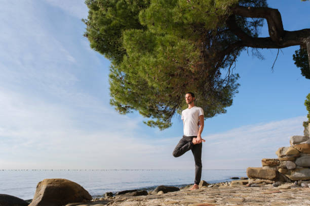 istock Attractive young man practicing yoga meditation and breathwork outdoors by the sea 1487018643