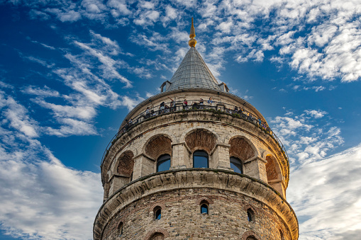 Istanbul, Turkey - September 03, 2022: Galata Tower was built by the Byzantine Emperor Anastasius as a lighthouse in 528, but the Genoese rebuilt the tower in 1349. The tower, which was damaged by the earthquake in the 1500s, was repaired by Architect Hayreddin. III. During the Selim period, a bay window was added to the upper floor of the tower. When the tower suffered another fire in 1831, II. Mahmut climbed two more floors above the tower. Finally restored again in 2020
