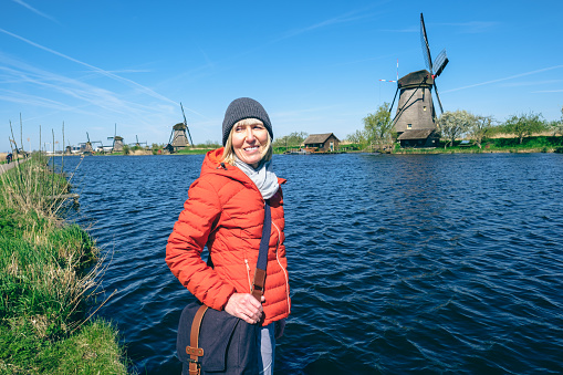 Female tourist beside the Kinderdijk windmills in The Netherlands.