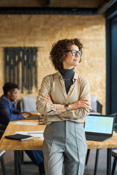 istock Young pretty business leader in quiet luxury attire looking through window 1487025077