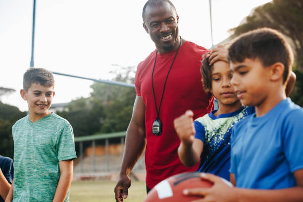 istock Coach training an elementary school football team 1487026460