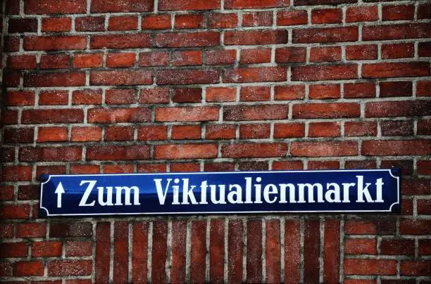 A street sign on a wall of bricks in Munich, Germany which is pointing to the famous Viktualienmarkt food market