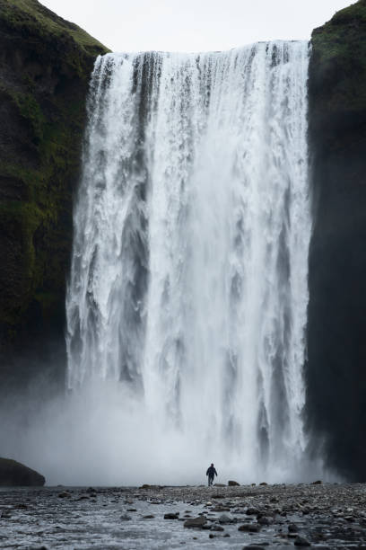 istock A person next to Skogafoss waterfall 1487029969