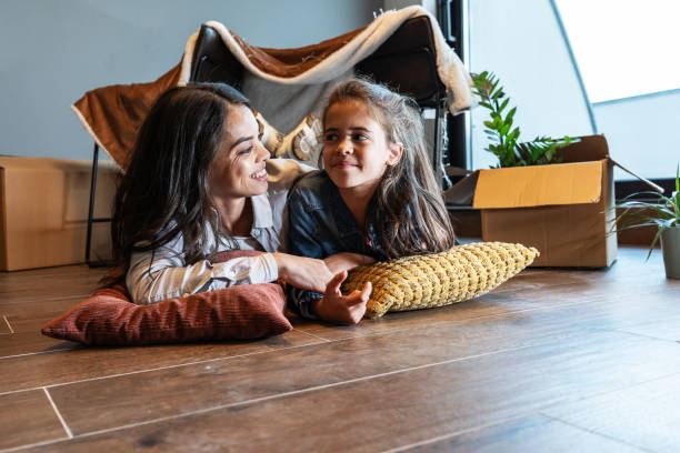 mutter und tochter liegen vor dem improvisierten zelt im wohnzimmer. - women group of people lying down mother stock-fotos und bilder