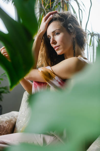 istock Sensual young woman sit between home plants 1487038056