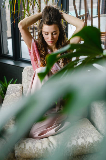 istock Woman on sofa in room with plants 1487038081