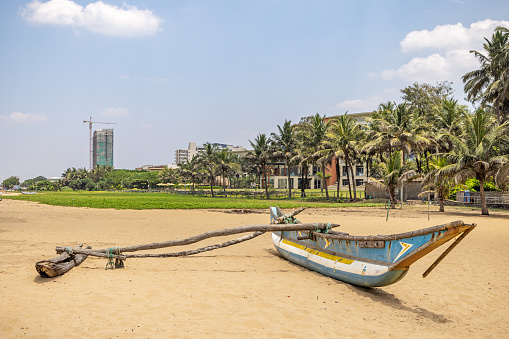 Negombo, Western Province, Sri Lanka - March 9th 2023:  Traditional outrigger canoe used for fishing from the beach