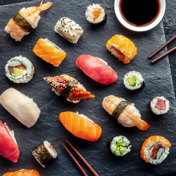 istock Sushi, overhead square shot with chopsticks and soy sauce. Rolls, maki, etc 1487039441