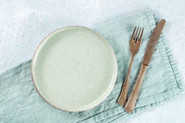 istock An empty green plate, with a fork and a knife, overhead flat lay shot 1487039460