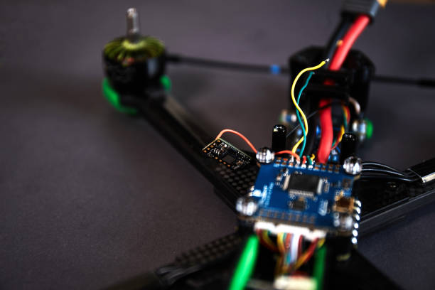 istock Close up of man's hands assembling a drone from parts, using tools, Preparing high speed racing quadcopter for flight. Repair drone before training process. 1487040951