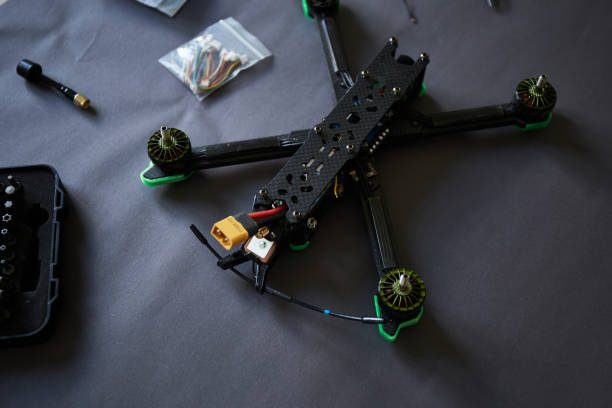 istock Close up of man's hands assembling a drone from parts, using tools, Preparing high speed racing quadcopter for flight. Repair drone before training process. 1487040971