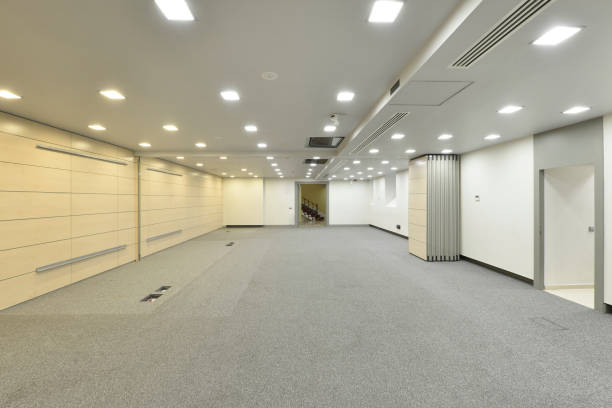 istock Large room to dedicate to empty offices, with floors covered with gray carpet and folding screens in the middle of the room 1487042009