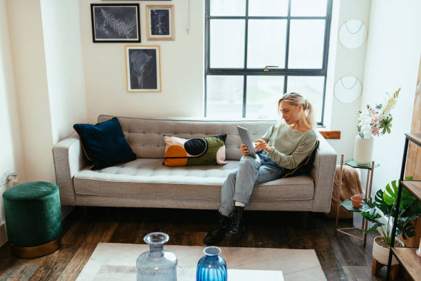 istock Beautiful Caucasian woman in modern apartment and using digital tablet 1487042048