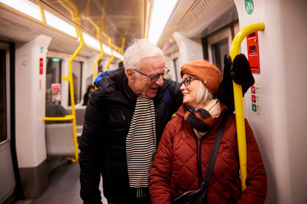 istock Senior couple talking and laughing while riding on a subway train 1487044636