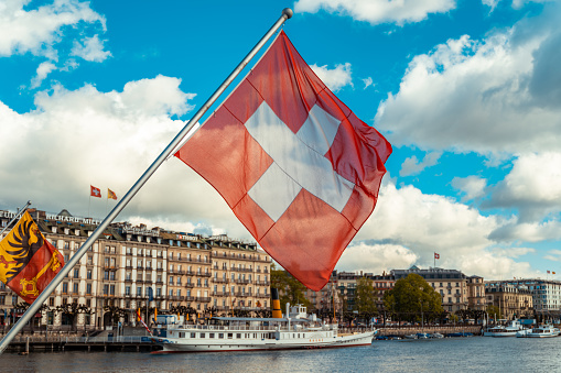 Swiss flag with view of Geneva city, Switzerland
