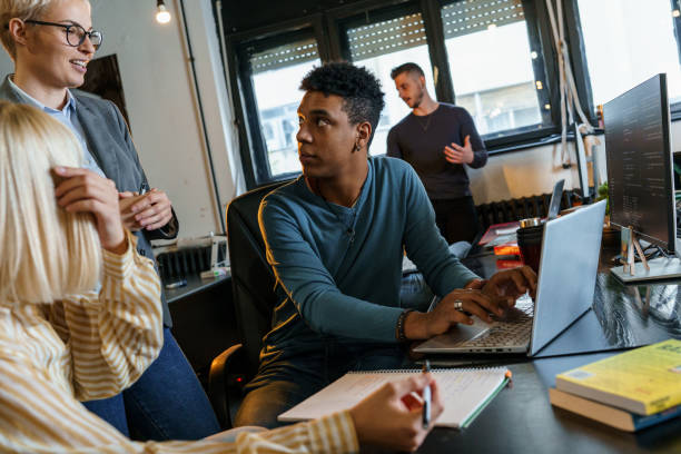 istock Group of casual team workers and programmers in the office working on a new project. 1487045623