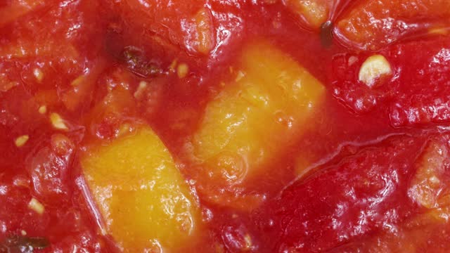 Bell peppers, tomatoes and paprika vegetables as a traditional Hungarian dish called lecsó circle rotation close up