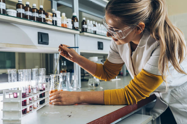 ブロンドの髪、女性の化学科学者、研究室で実験をする学生。 - laboratory assistant healthcare and medicine chemistry ストックフォトと画像