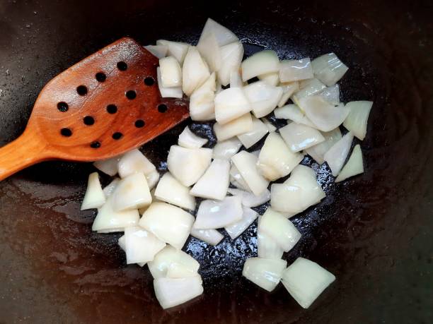 istock Frying Chopped Onion in cooking pan - food preparation. 1487053592