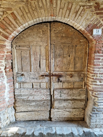 This image features an ornately arched wooden door with intricate paneling
