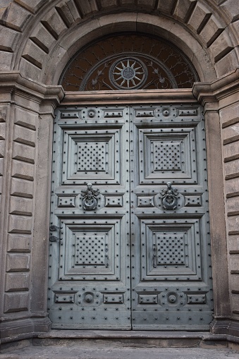 An inviting wooden door with a metal star adorning its center is situated next to a window frame with no glass