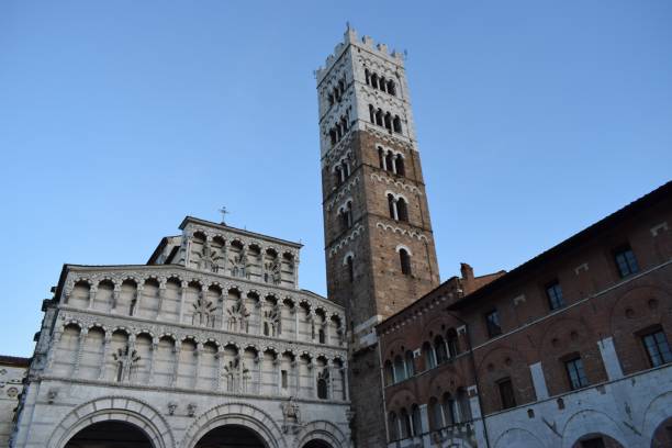 istock a tall tower with a clock on it and a building in the back 1487054669
